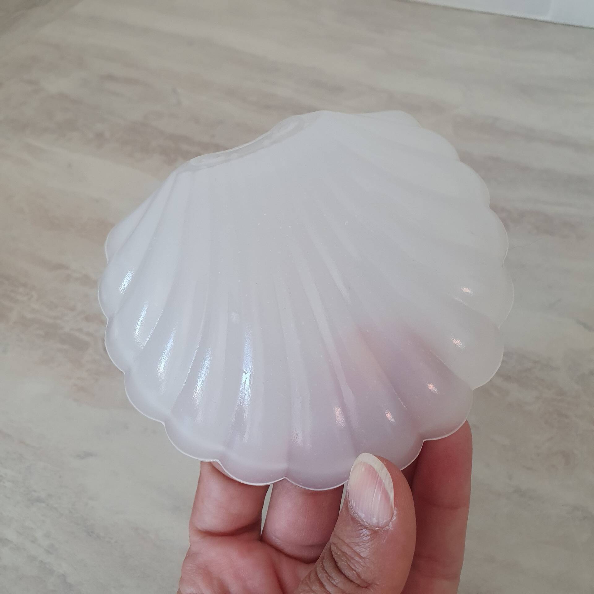 Scallop shell butter dish in stainless steel with its white glass saucer.