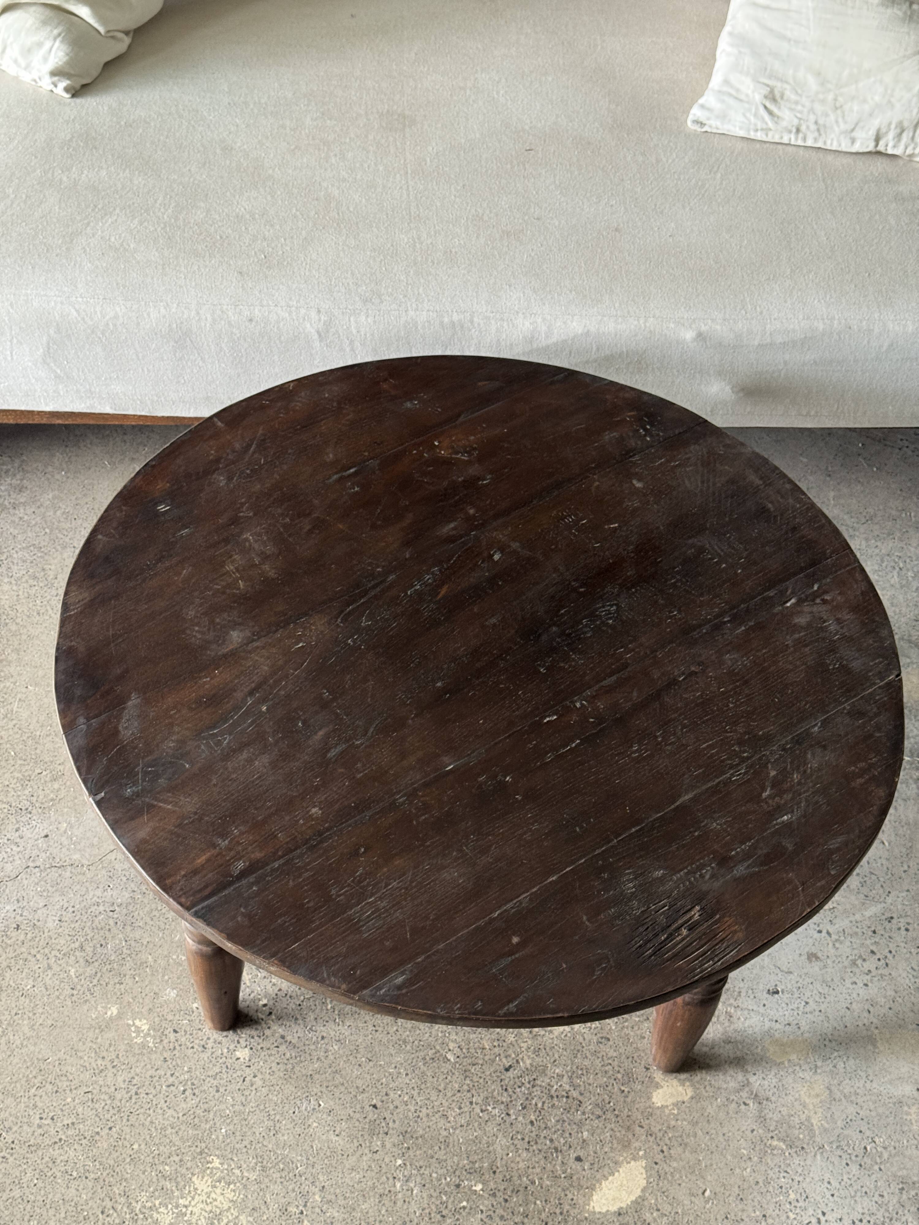 Coffee table, round antique Indonesian teak table with straight legs.