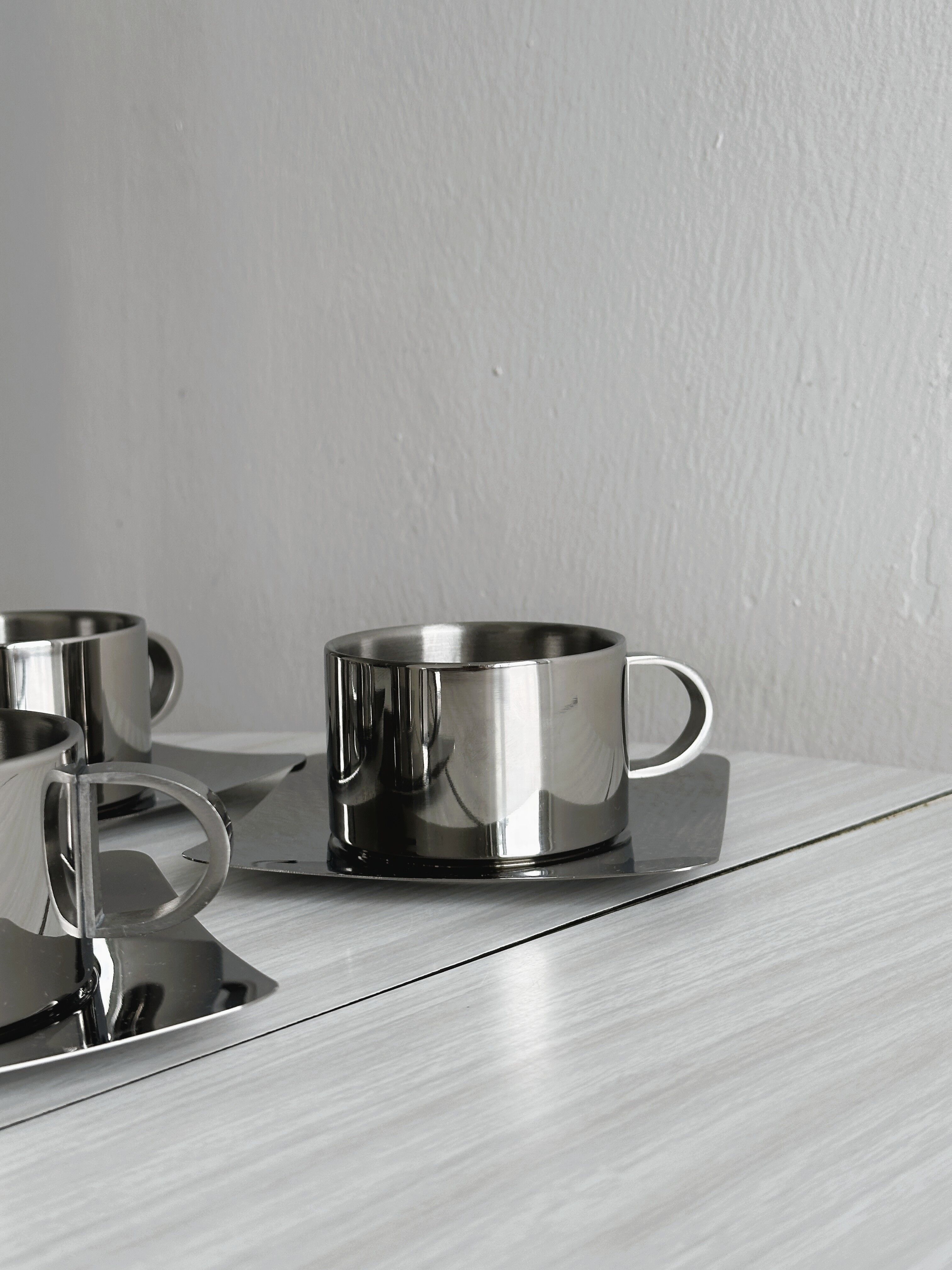 set of 4 stackable stainless steel coffee cups with saucers