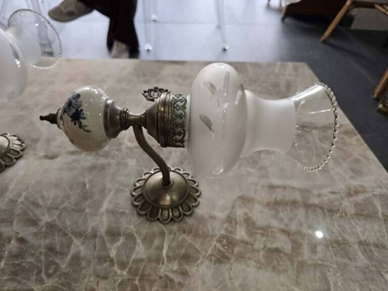 Pair of vintage wall sconces in brass, porcelain, and frosted glass.