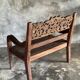 Small antique Indonesian bench in carved teak with plant and floral motifs.