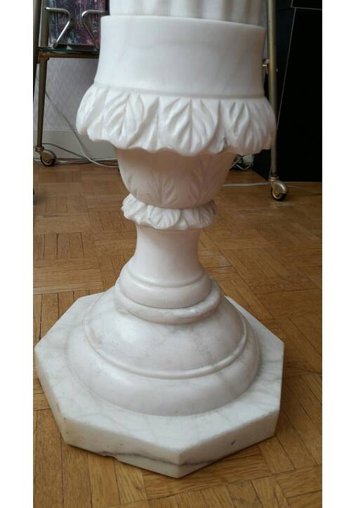 Fluted white marble stand column with floral motifs.
