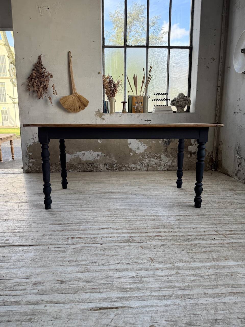 Oak farmhouse table with turned black legs.