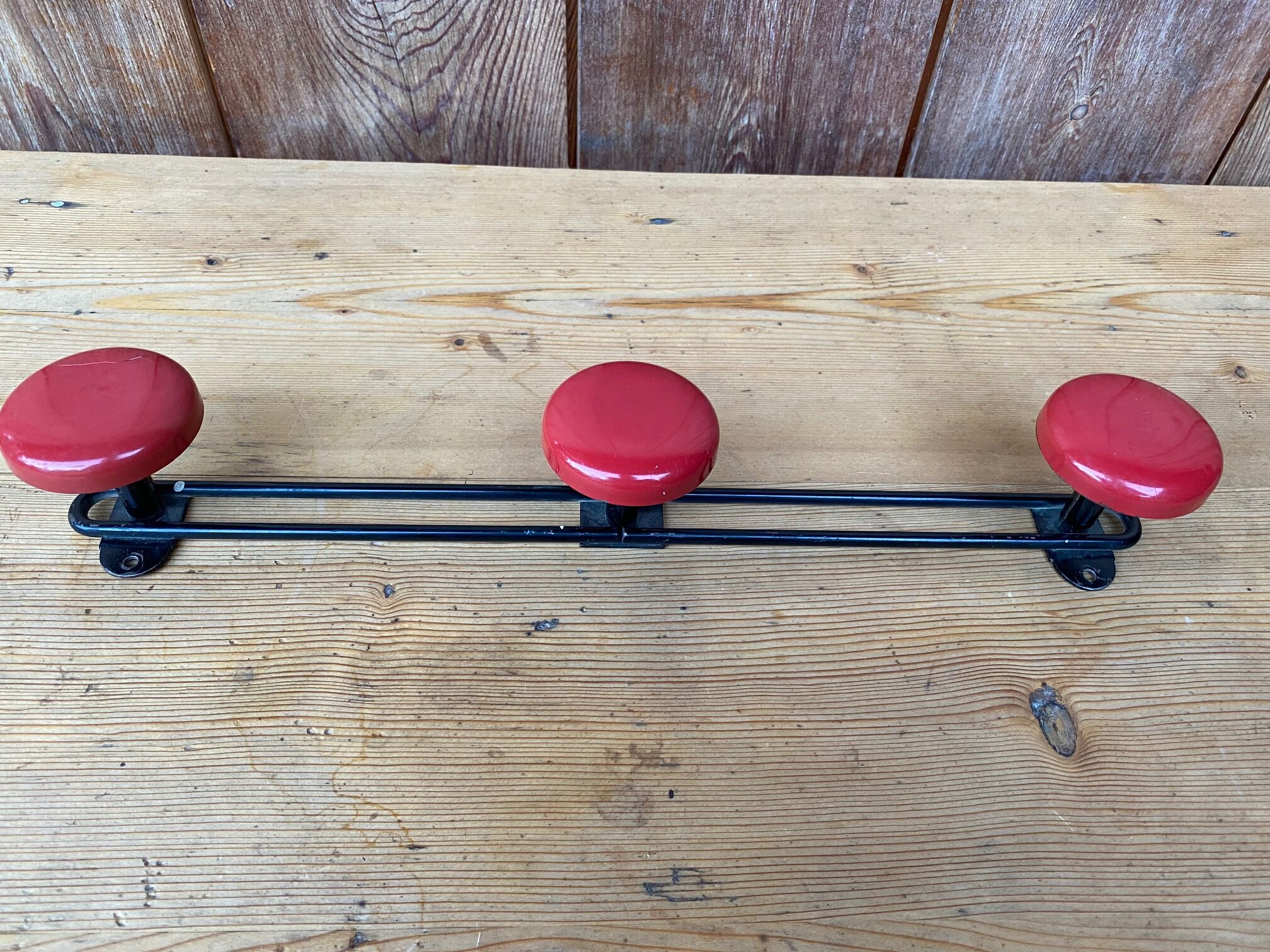 Wall coat holder in vintage red metal.