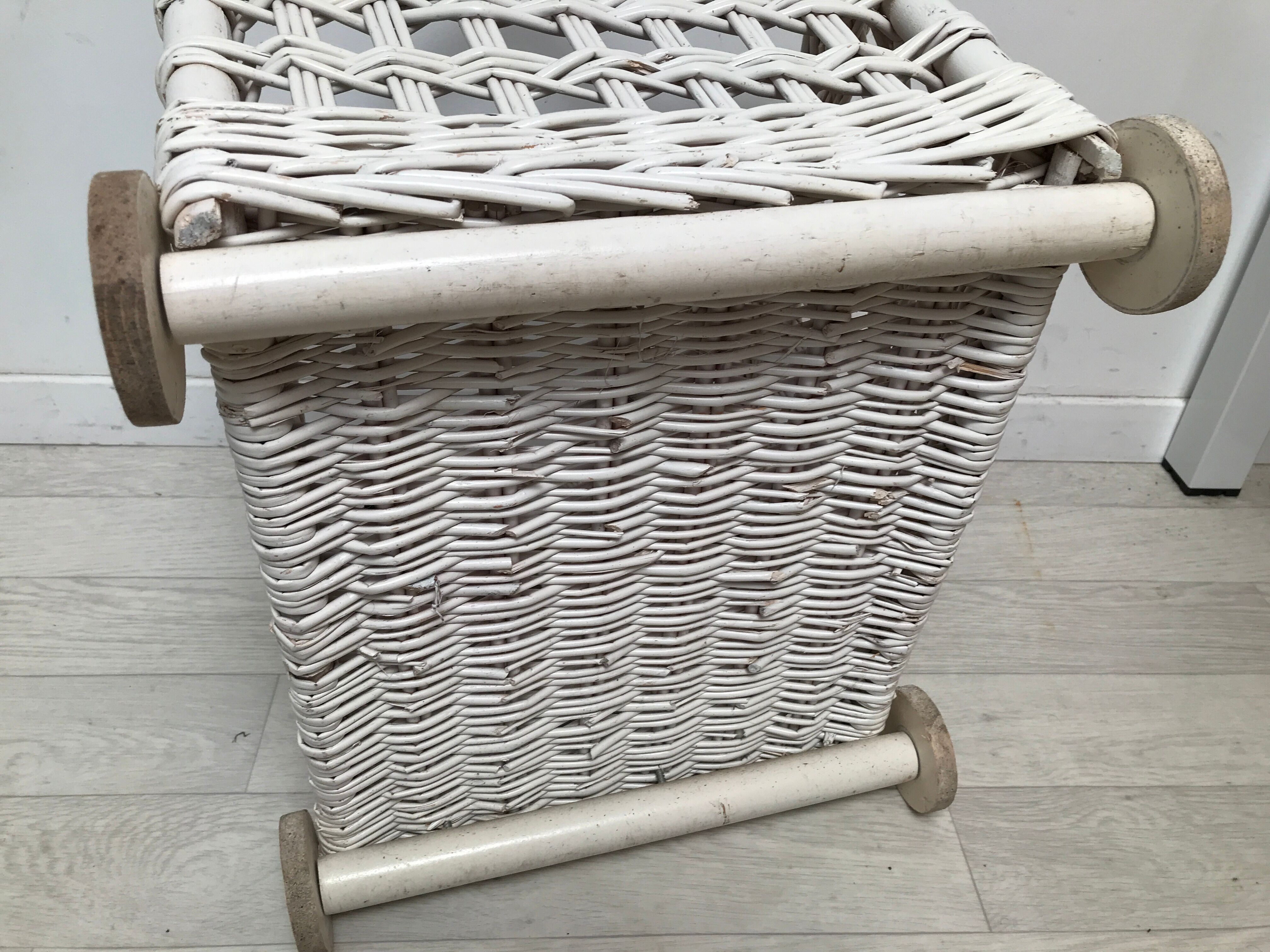 Wicker laundry basket on vintage wooden wheels