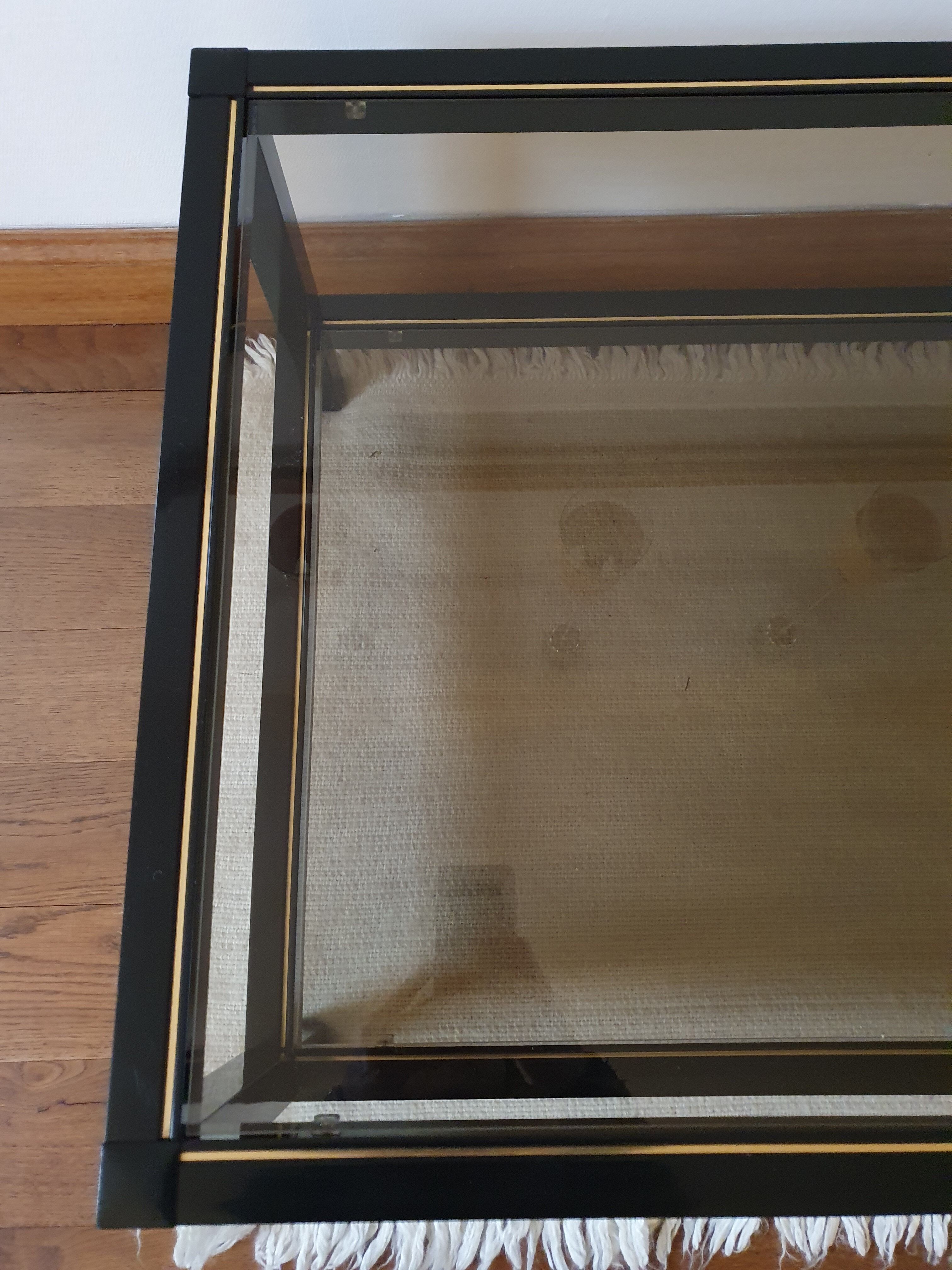 Black and gold coffee table with a double smoked glass top