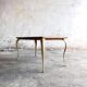 Table basse vintage avec pieds dorés et plateau incrusté de motifs géométriques en placage de bois brun clair