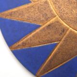 Relief mural signed in ceramic, sun with blue and gold face, 1990s.