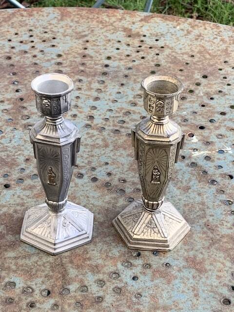 Pair of metal candlesticks, chiseled with a statuette in front, rose pattern in relief, art deco
