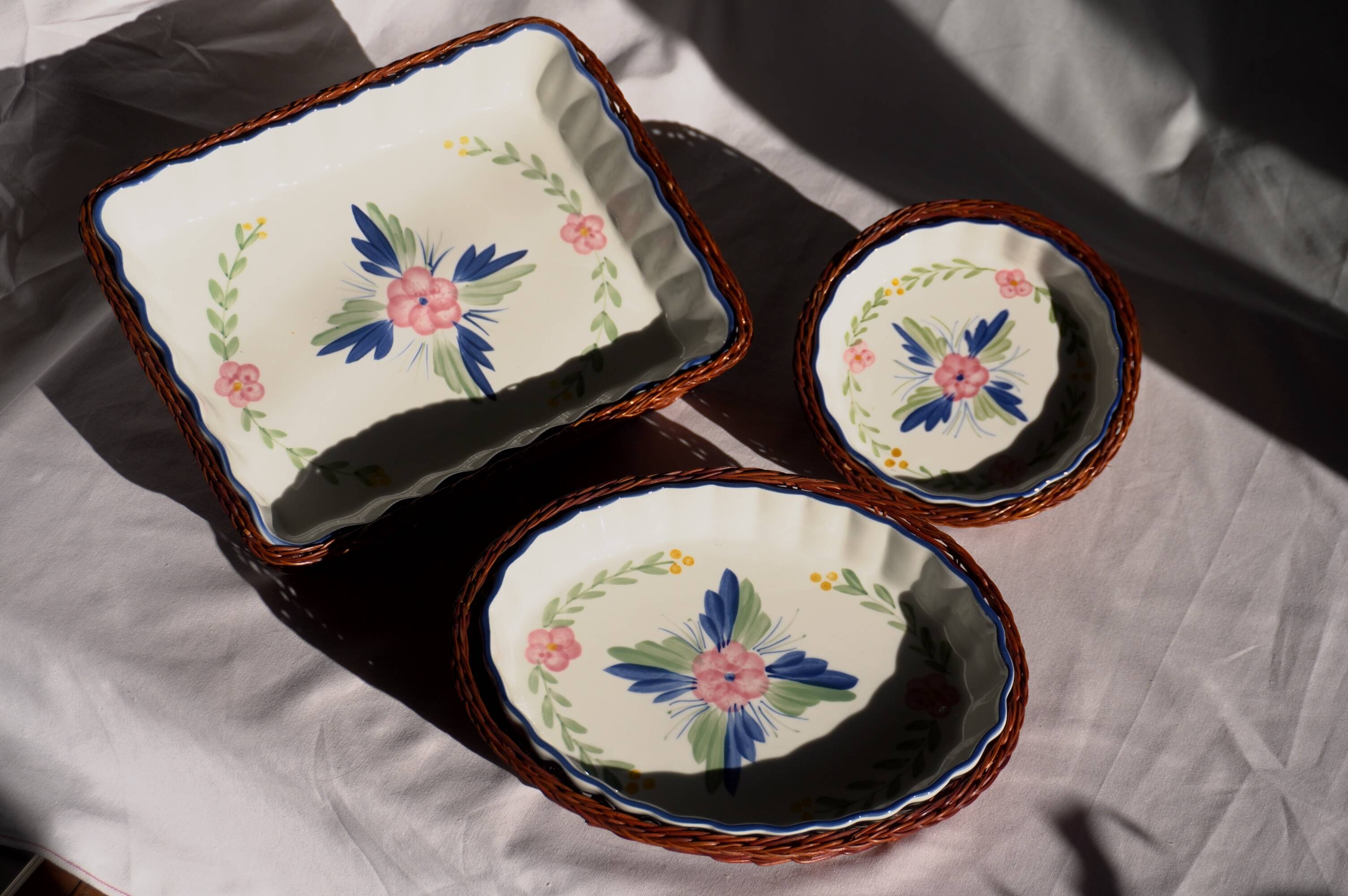 Set of 3 porcelain dishes with floral decorations, with wicker supports.