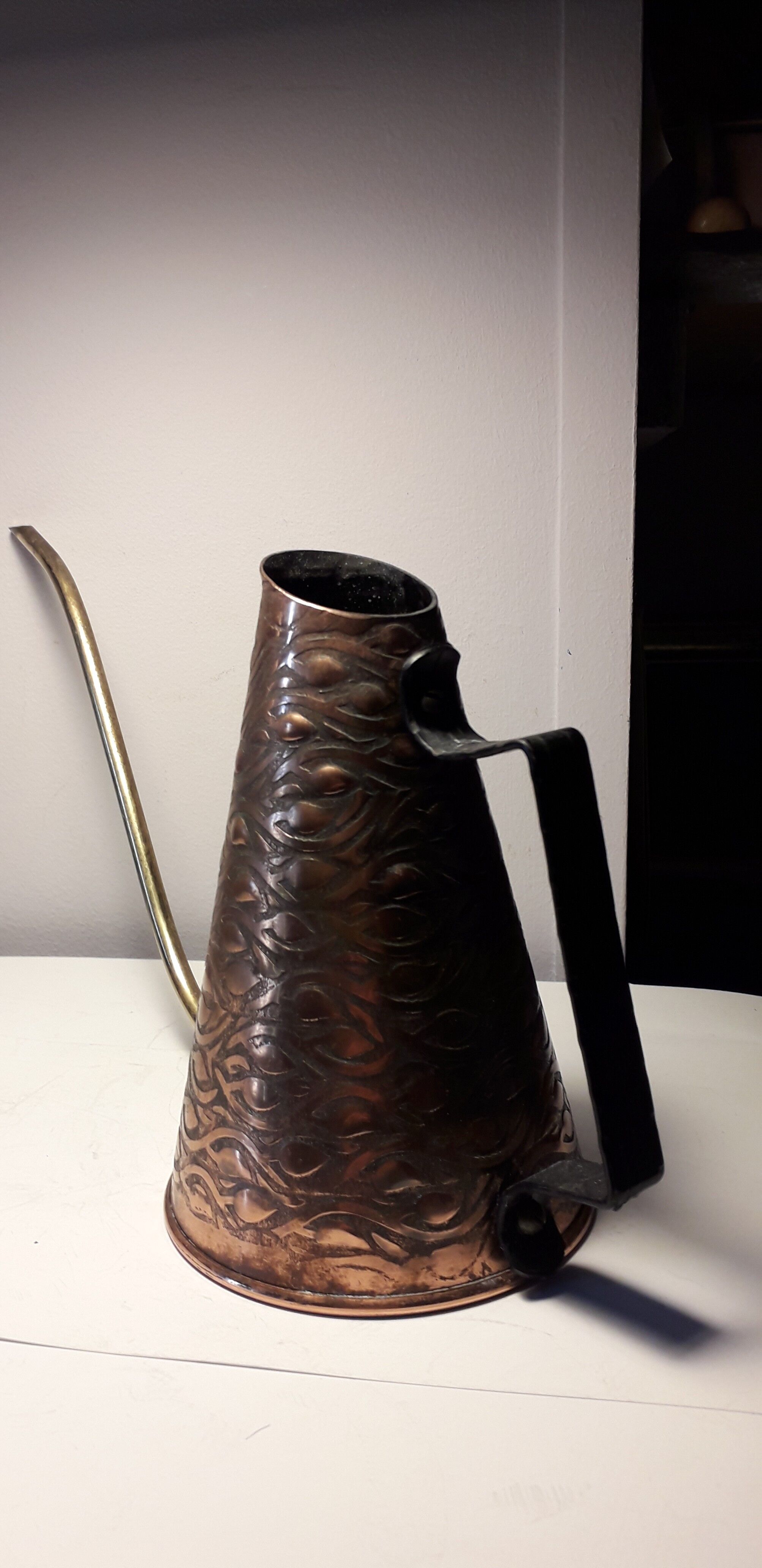 Old watering can in red copper and brass