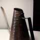 Old watering can in red copper and brass