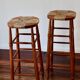 Antique wooden bar stool with a straw seat
