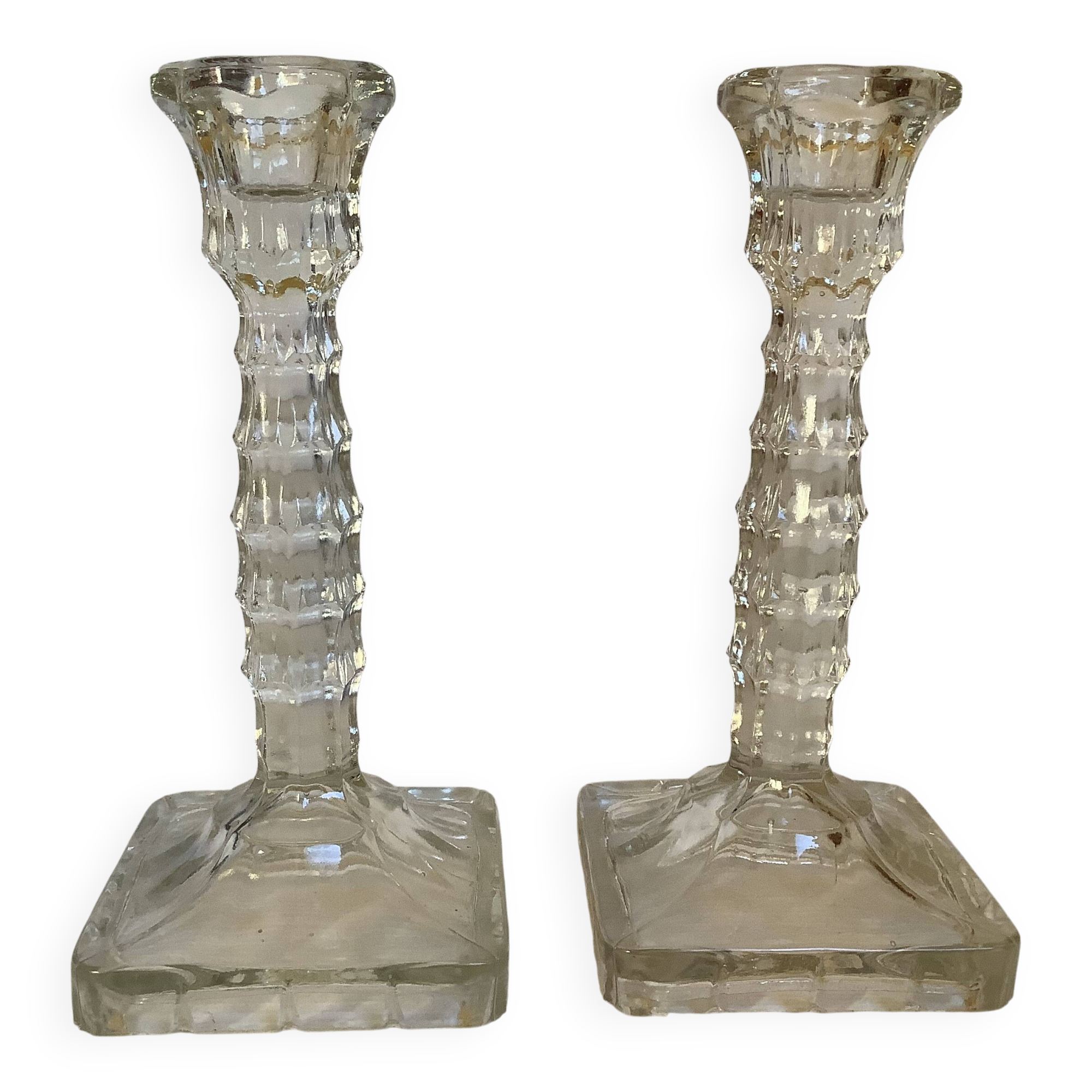 Pair of tall candle holders in the shape of a flower with a square base.