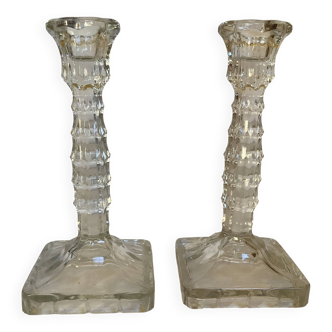 Pair of tall candle holders in the shape of a flower with a square base.