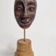 Expressive sculpted head in patinated terracotta on wooden base, 14 cm