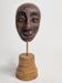 Expressive sculpted head in patinated terracotta on wooden base, 14 cm