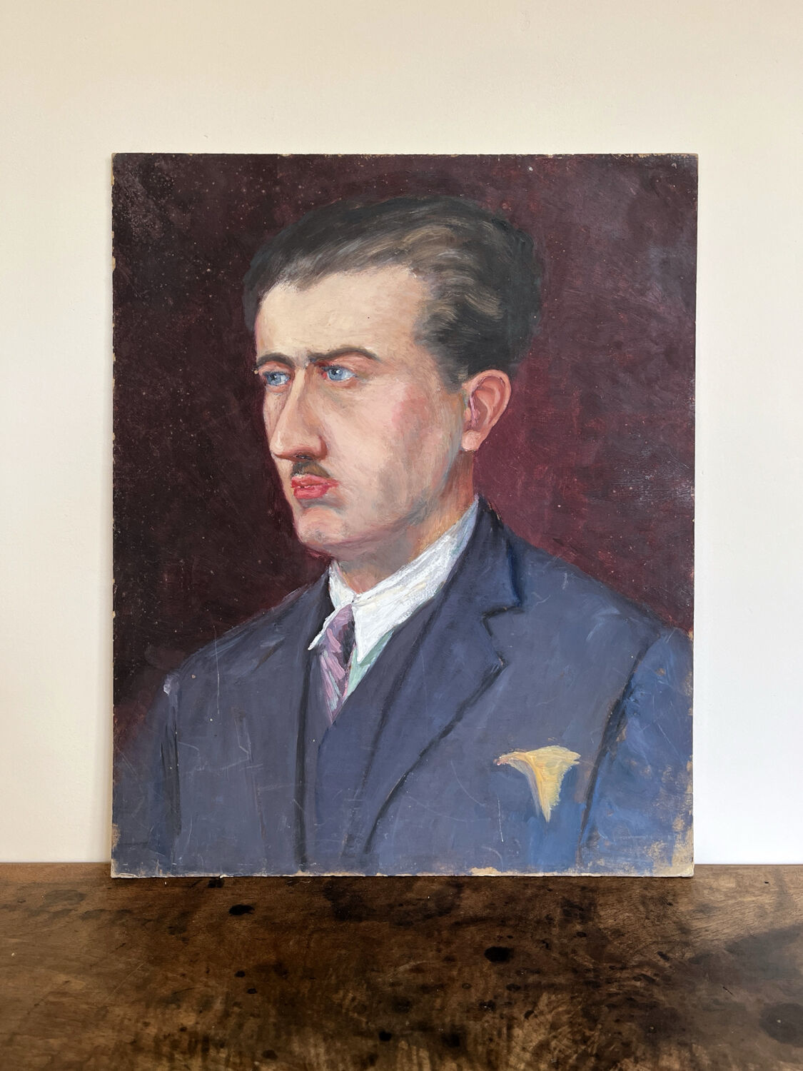 Old oil painting on cardboard portrait of a man in a blue suit