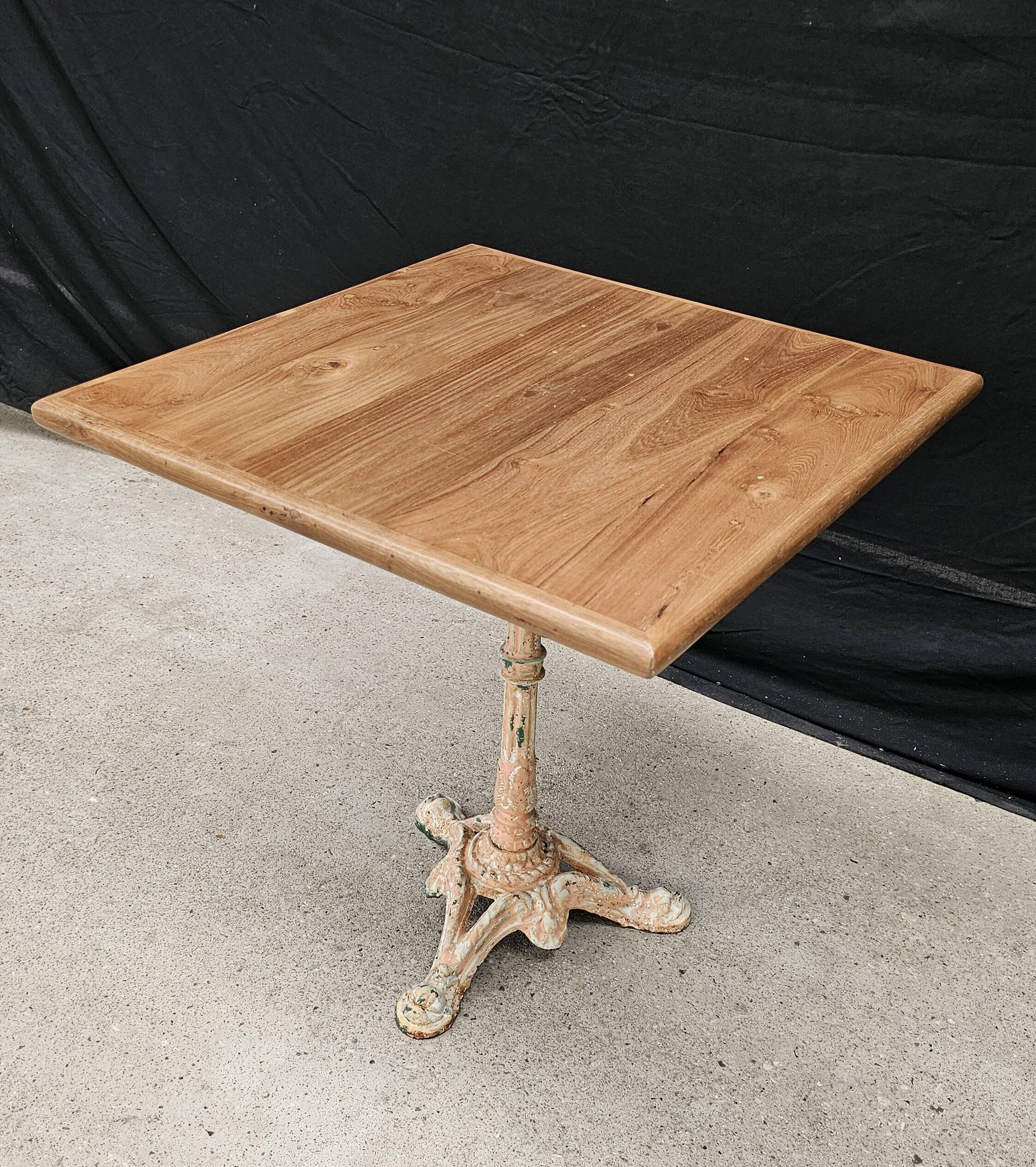 Bistro table with cast iron base and solid teak top