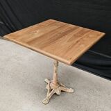 Bistro table with cast iron base and solid teak top