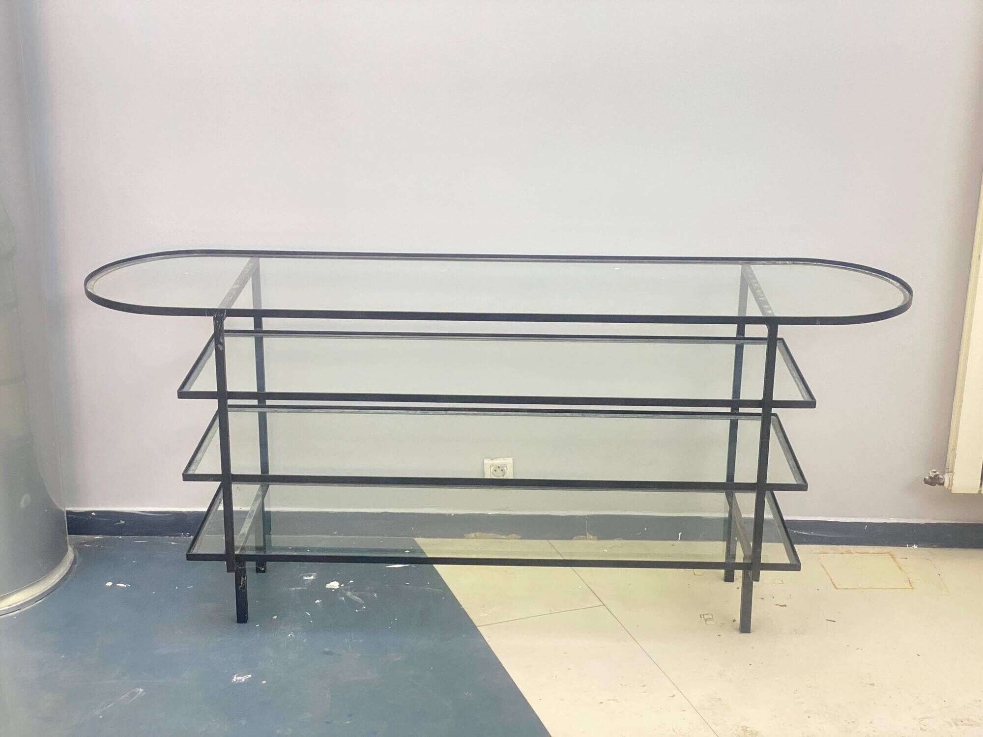Mid-century console with glass top and metal frame.