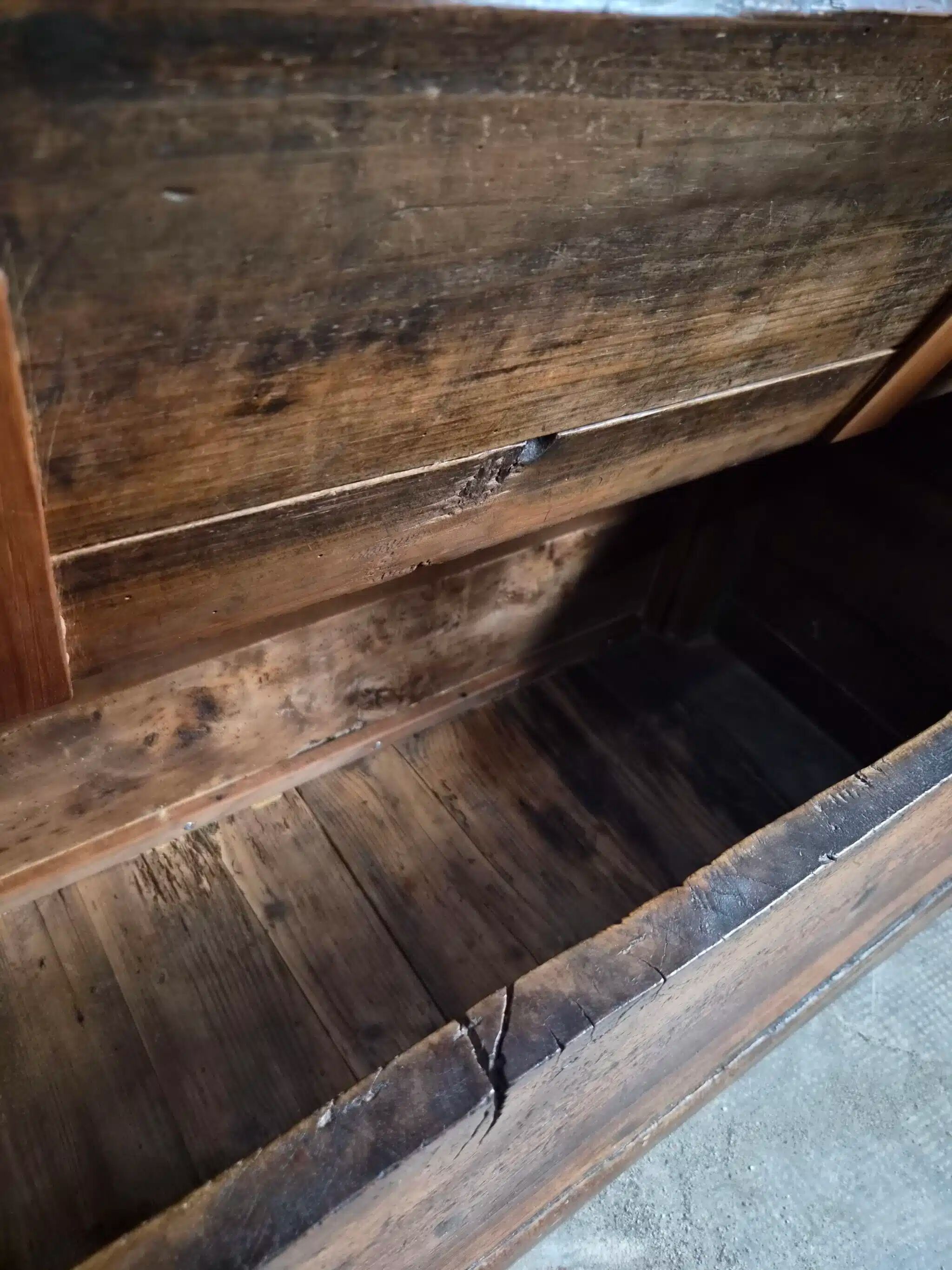 Rustic French antique storage bench from the 18th century in walnut and pine.