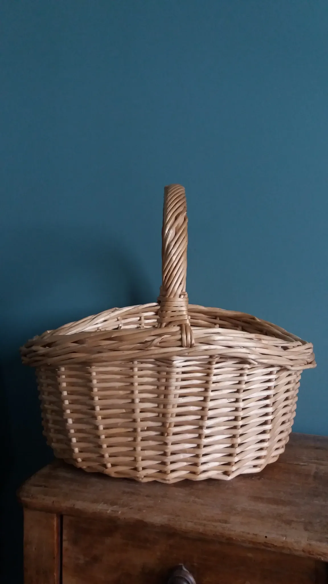Handcrafted wicker basket with a handle.