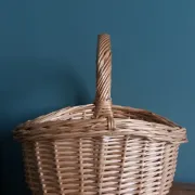 Handcrafted wicker basket with a handle.