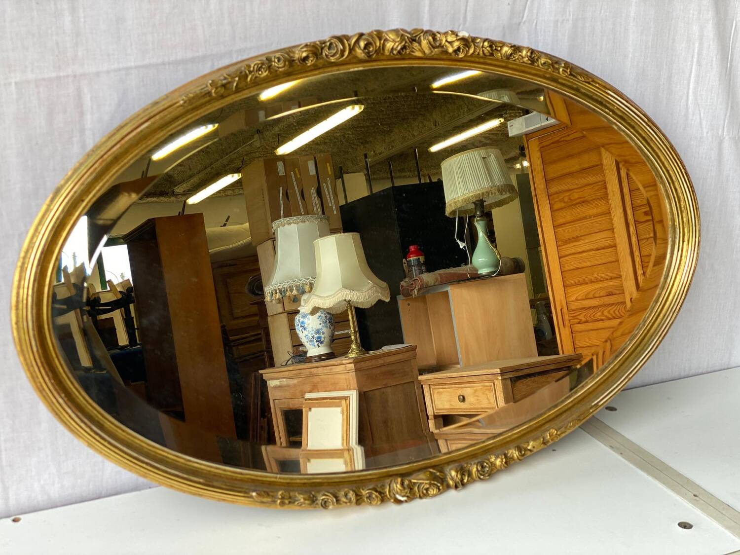 Vintage carved and gilded oval wall mirror
