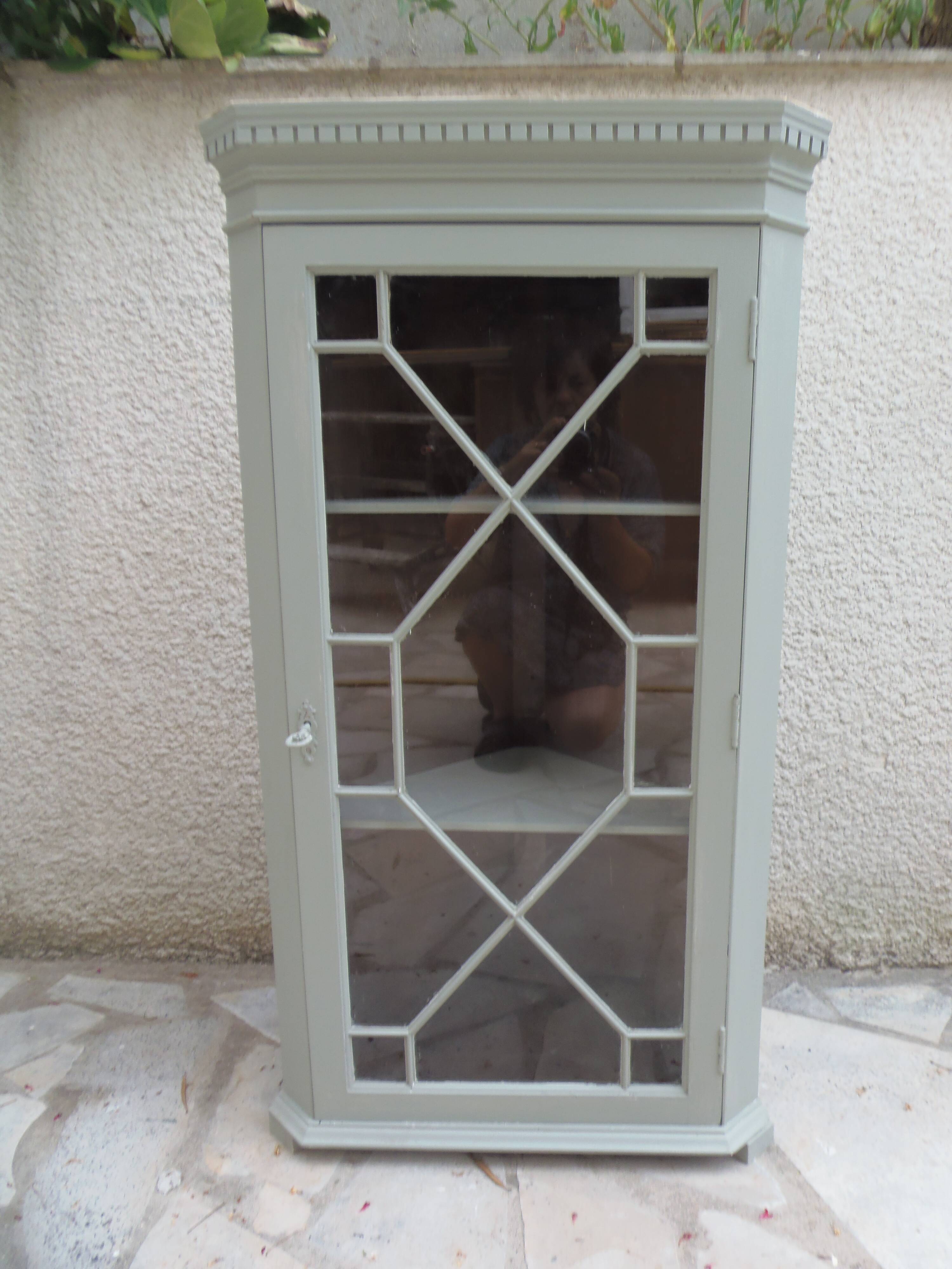 Vintage English corner display cabinet enhanced in grey-green with a wooden top.