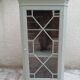 Vintage English corner display cabinet enhanced in grey-green with a wooden top.
