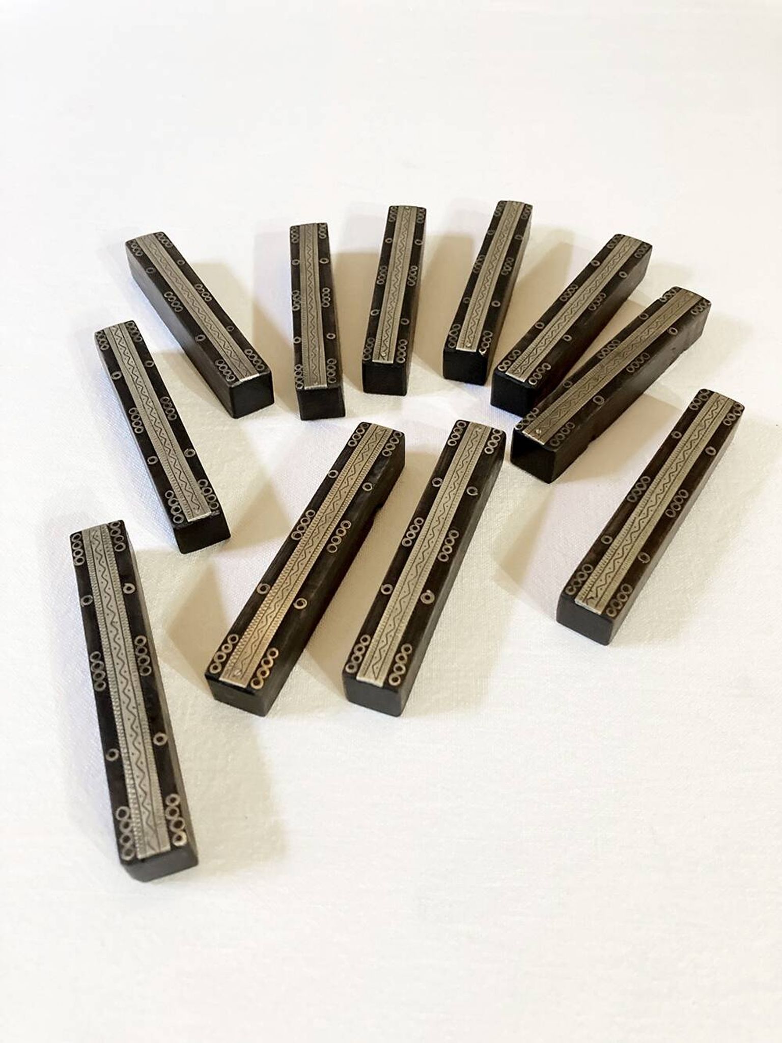 Set of 11 ebony wood knife rests with brass inlay