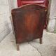 Antique club chair in patinated brown leather, early 20th century English style.