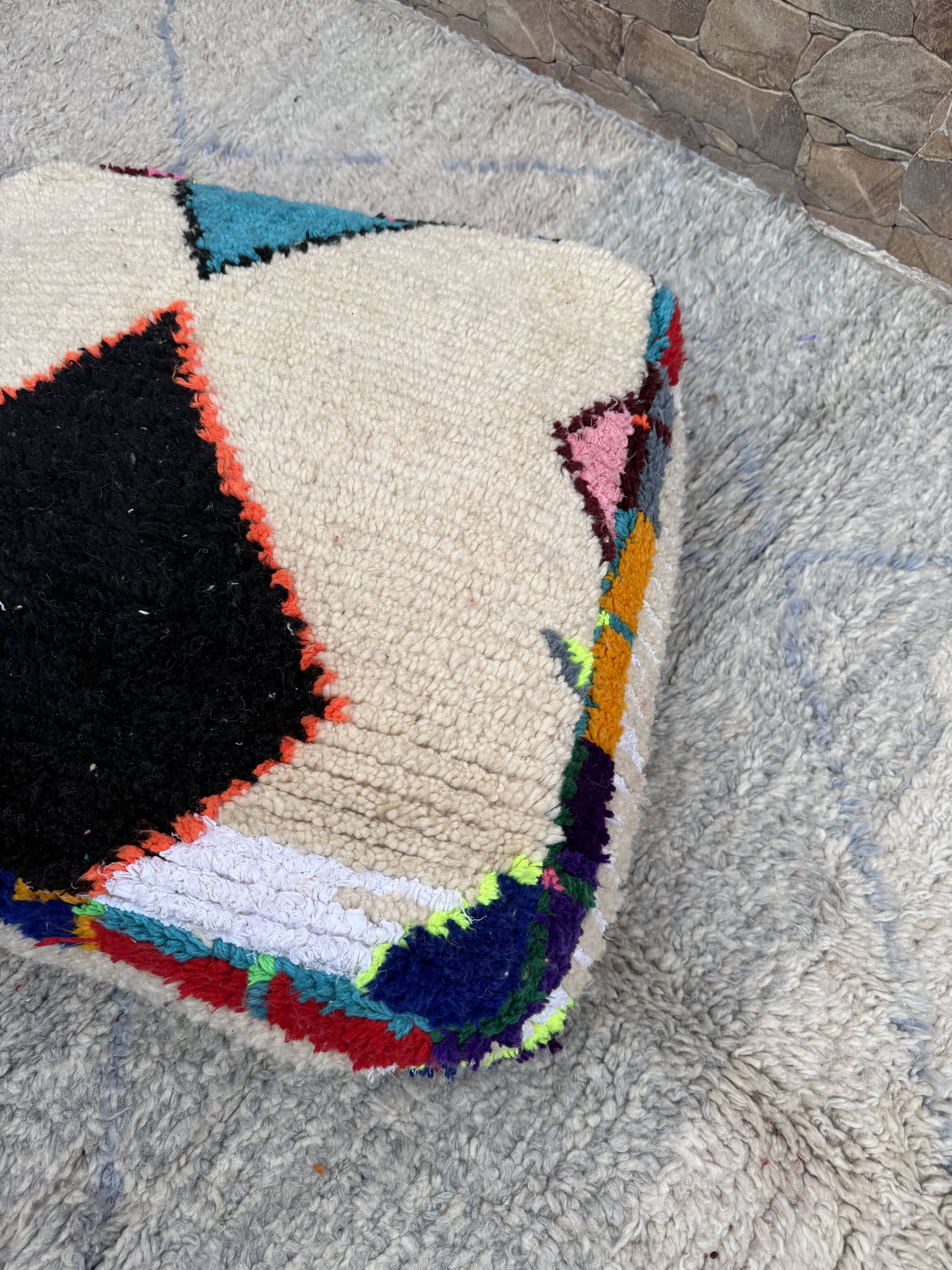 Berber floor pouf: Handwoven Moroccan wool cushion.
