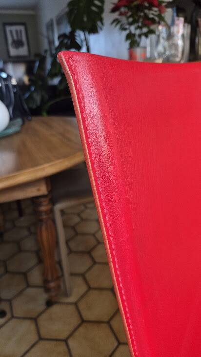 Red leather dining chairs by Arper