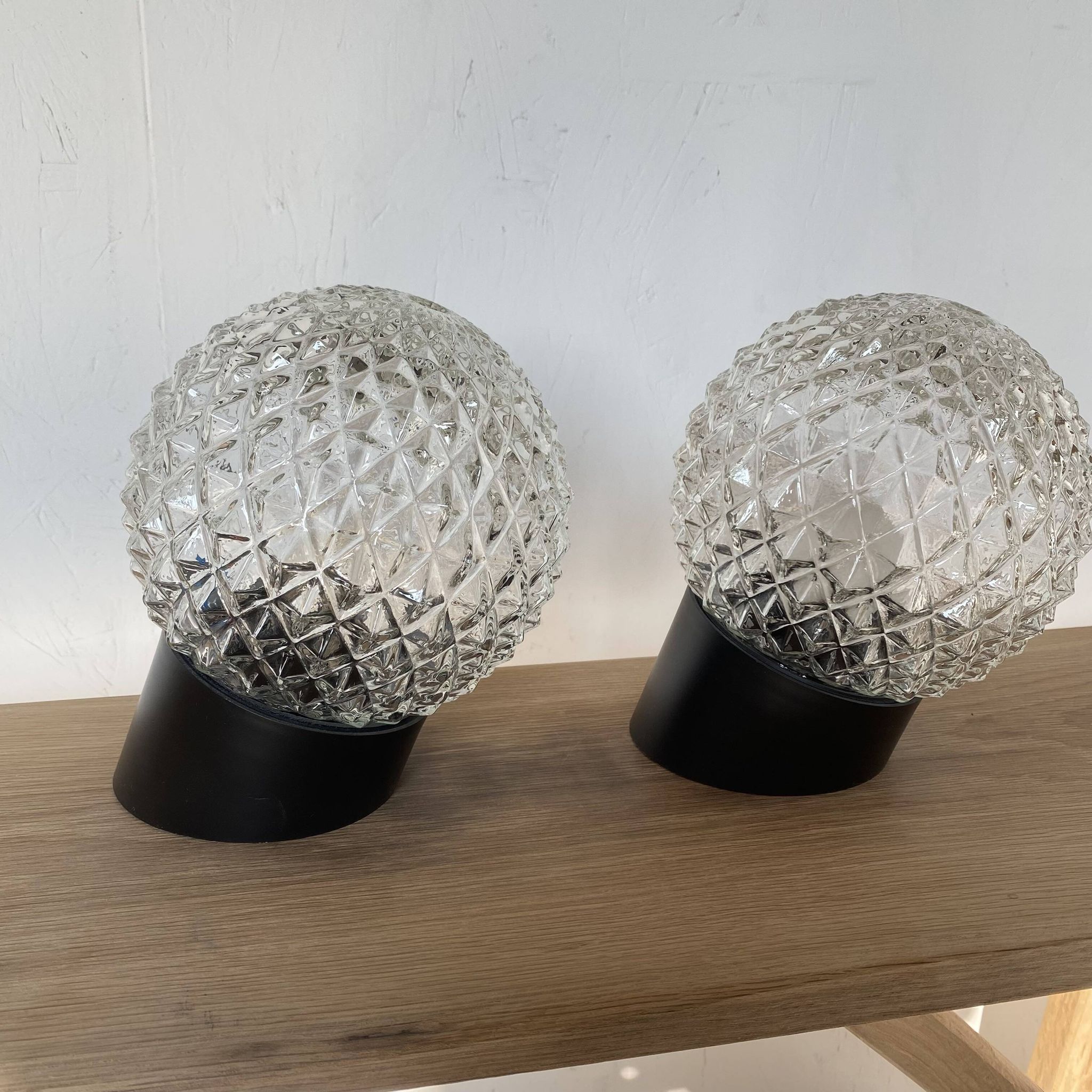 Pair of slanted glass wall lights with black plastic base, decorative v