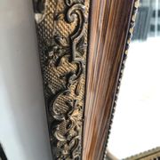 Old mirror with wooden frame and plaster moldings