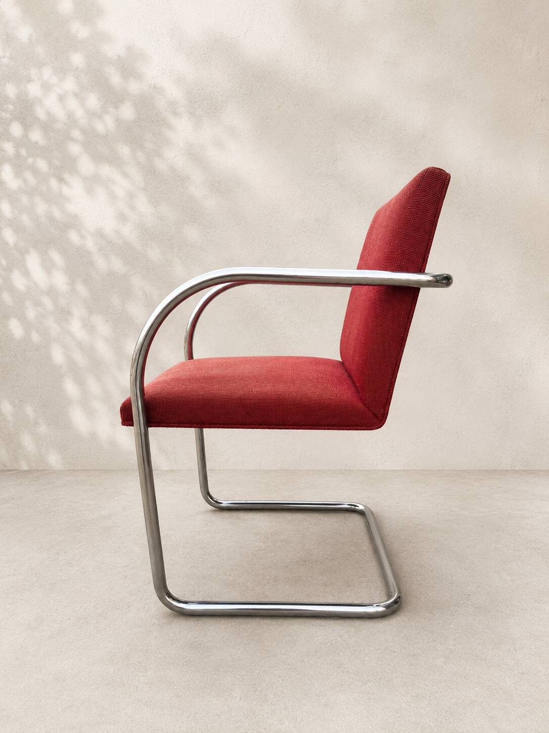 Vintage cantilever chair in chrome and burgundy fabric.