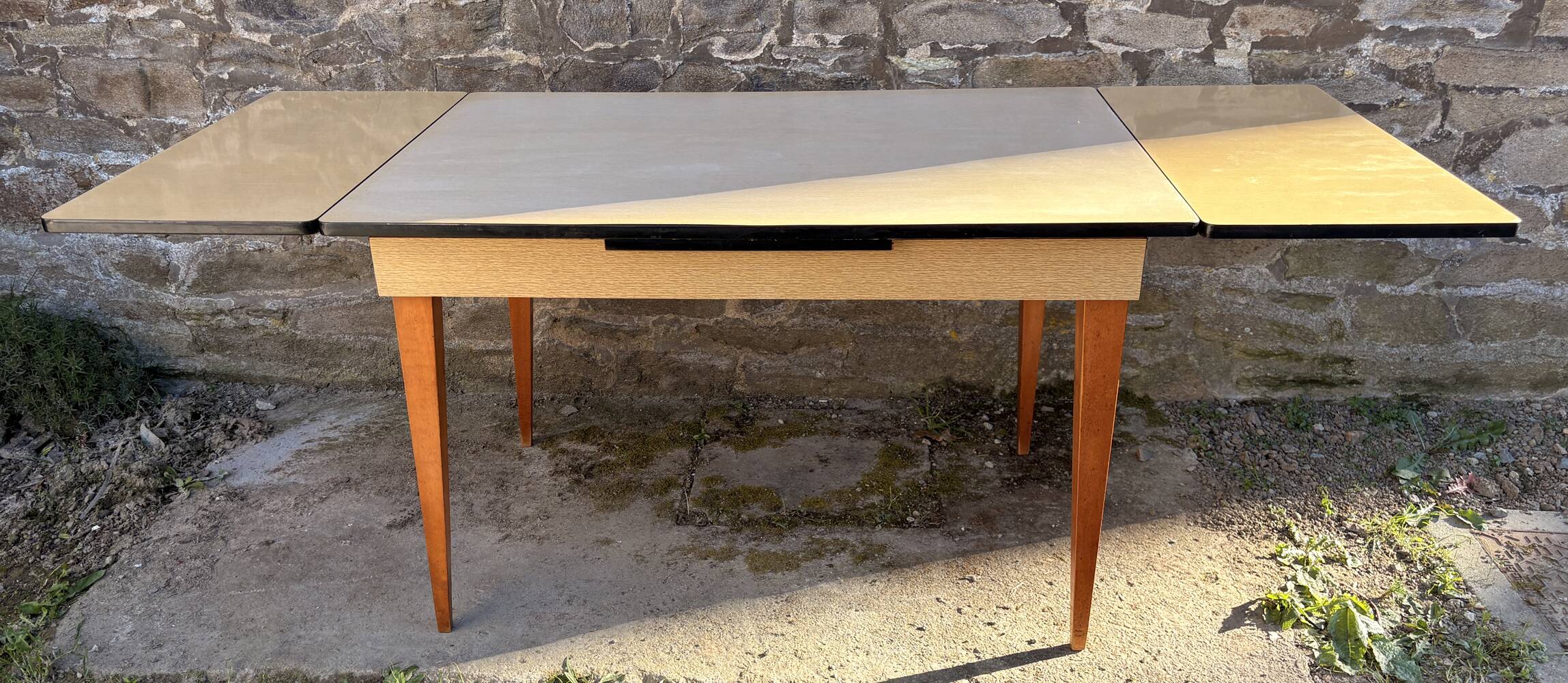 Beige French modernist extendable table, wooden legs, circa 1955.