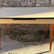 Beige French modernist extendable table, wooden legs, circa 1955.