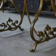 Side table with a gilt wrought iron base attributed to Gilbert Poillerat, with a travertine top, 1940s