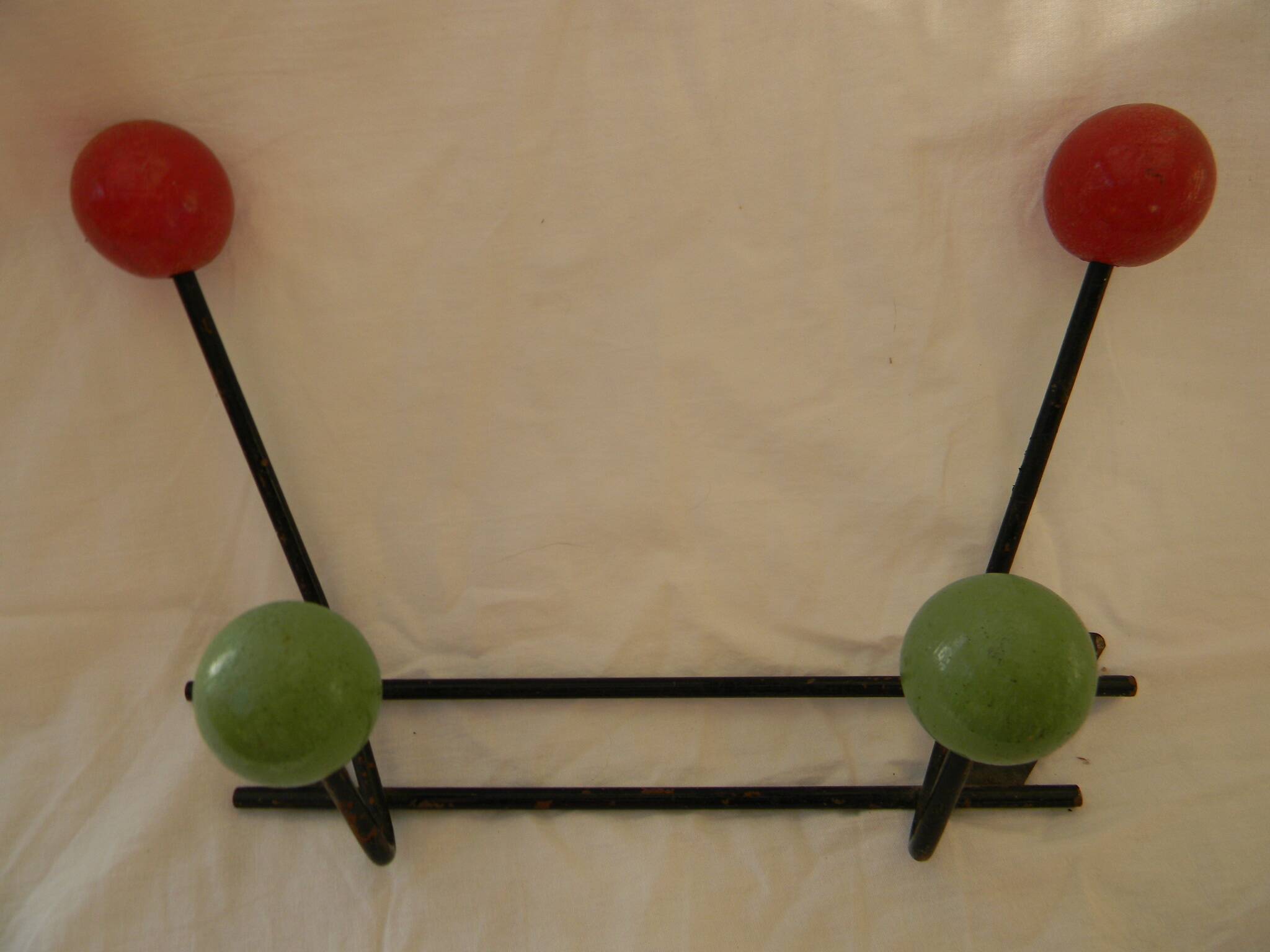 Small wrought iron coat rack with wooden balls.