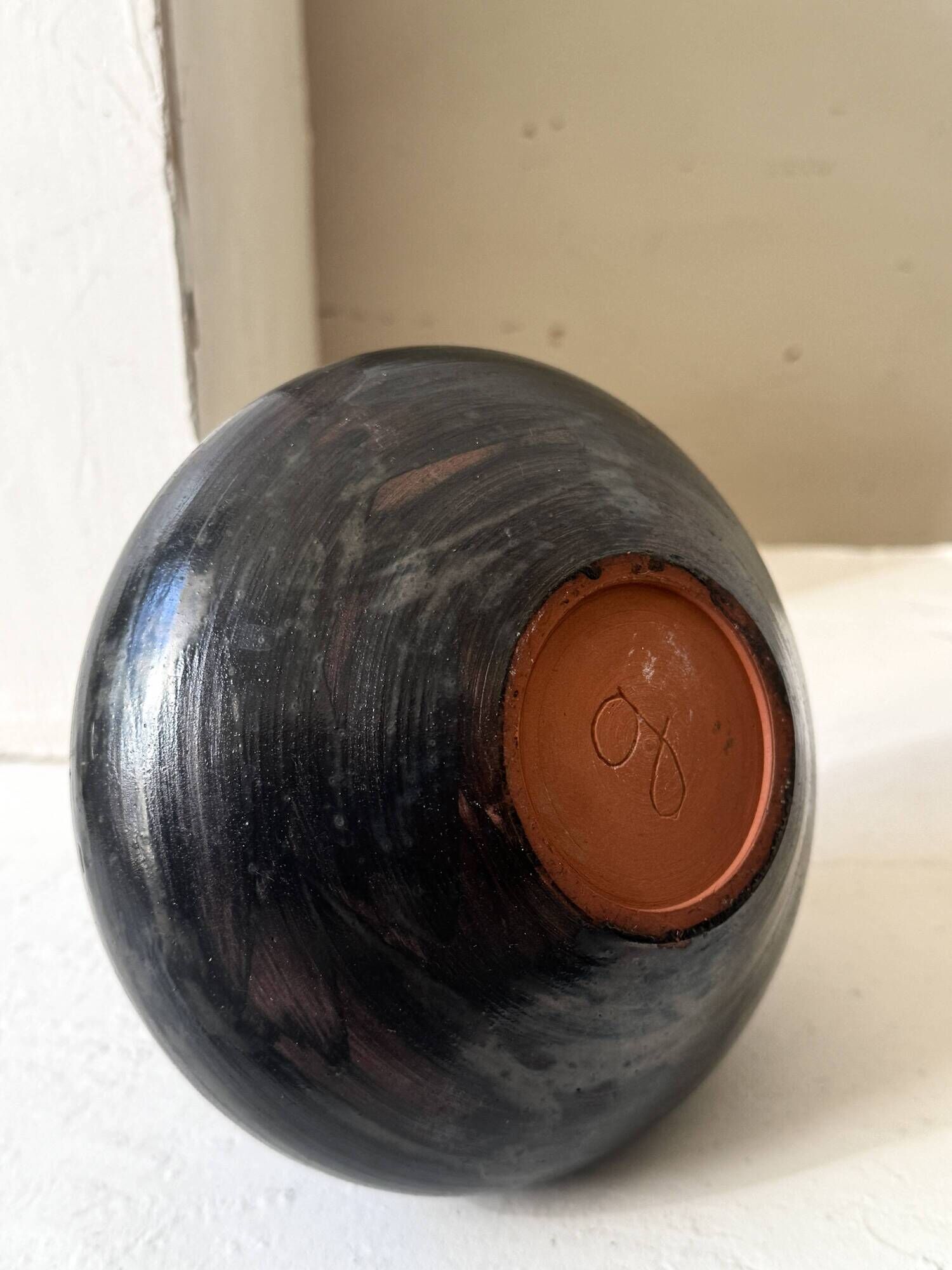 Glazed black ceramic vase with a single stem, signed, circa 1950.