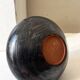 Glazed black ceramic vase with a single stem, signed, circa 1950.