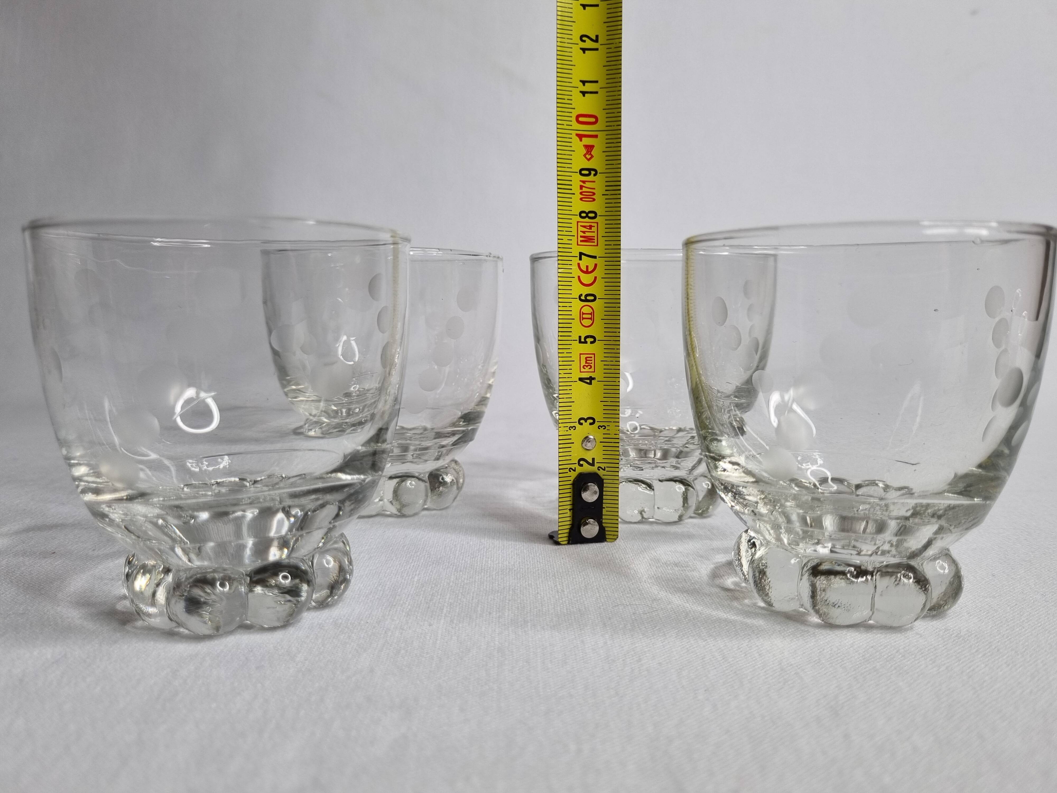 Set of four Art Deco style engraved crystal glasses on spherical feet