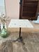 Bistro table with a raw wood top and a central cast iron base.