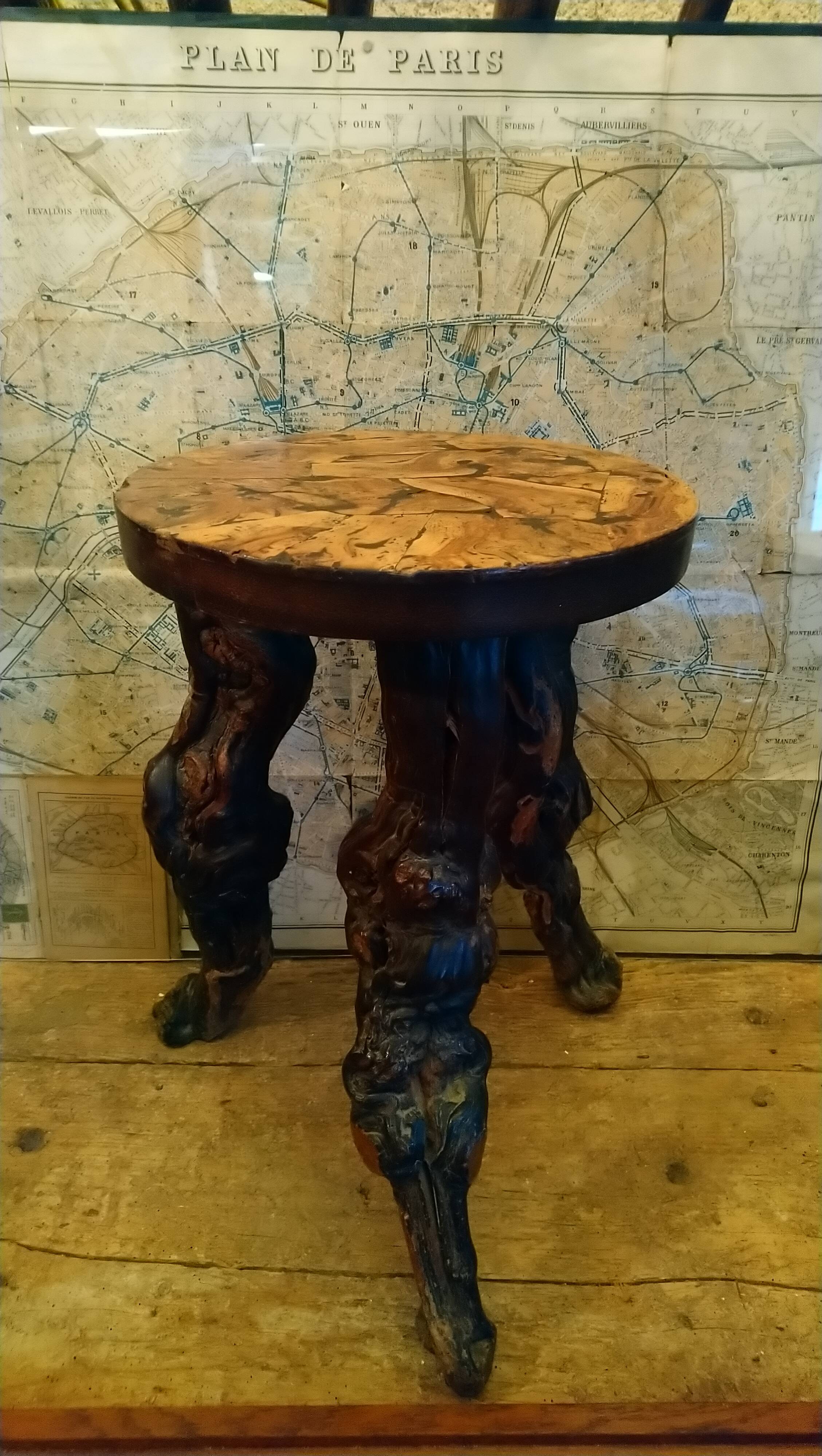 Brutalist tripod stool made from vine stumps.