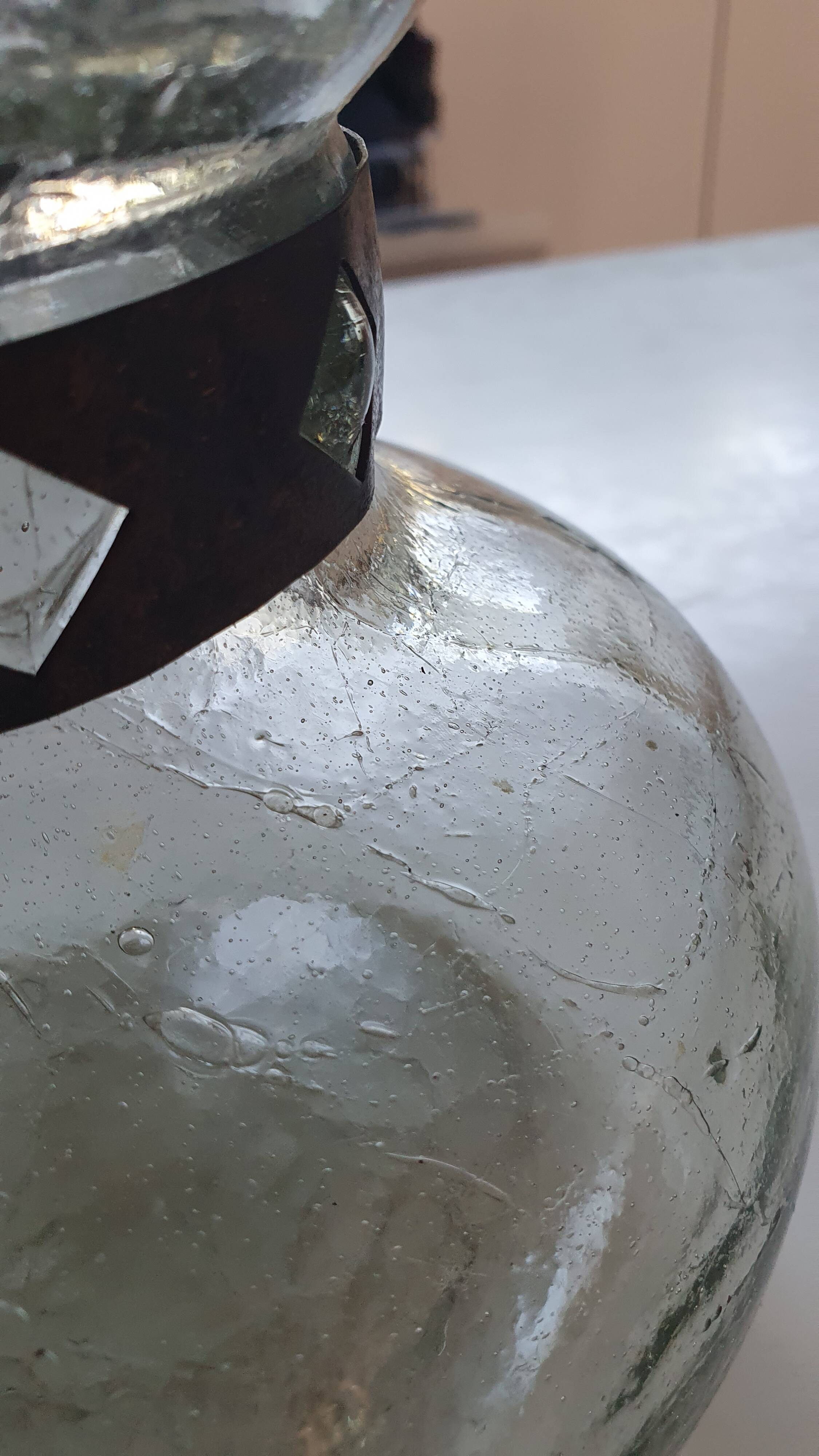 Cracked glass vase encircled with wrought iron.