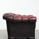 Classic cowhide chesterfield buttonseat armchair in a beautiful red colour and elegant round shapes