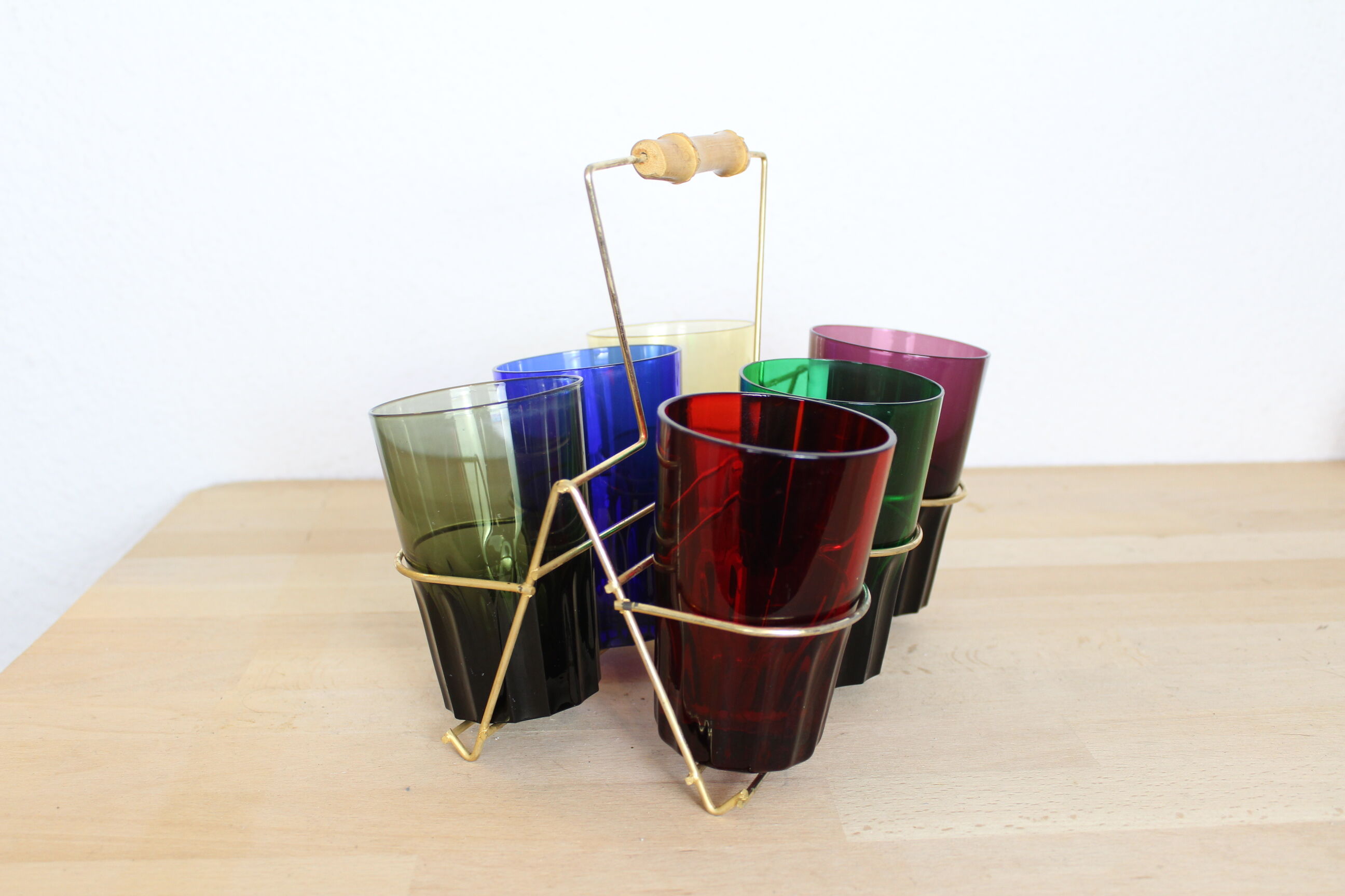 Set of 6 coloured glasses in their brass holder, basket